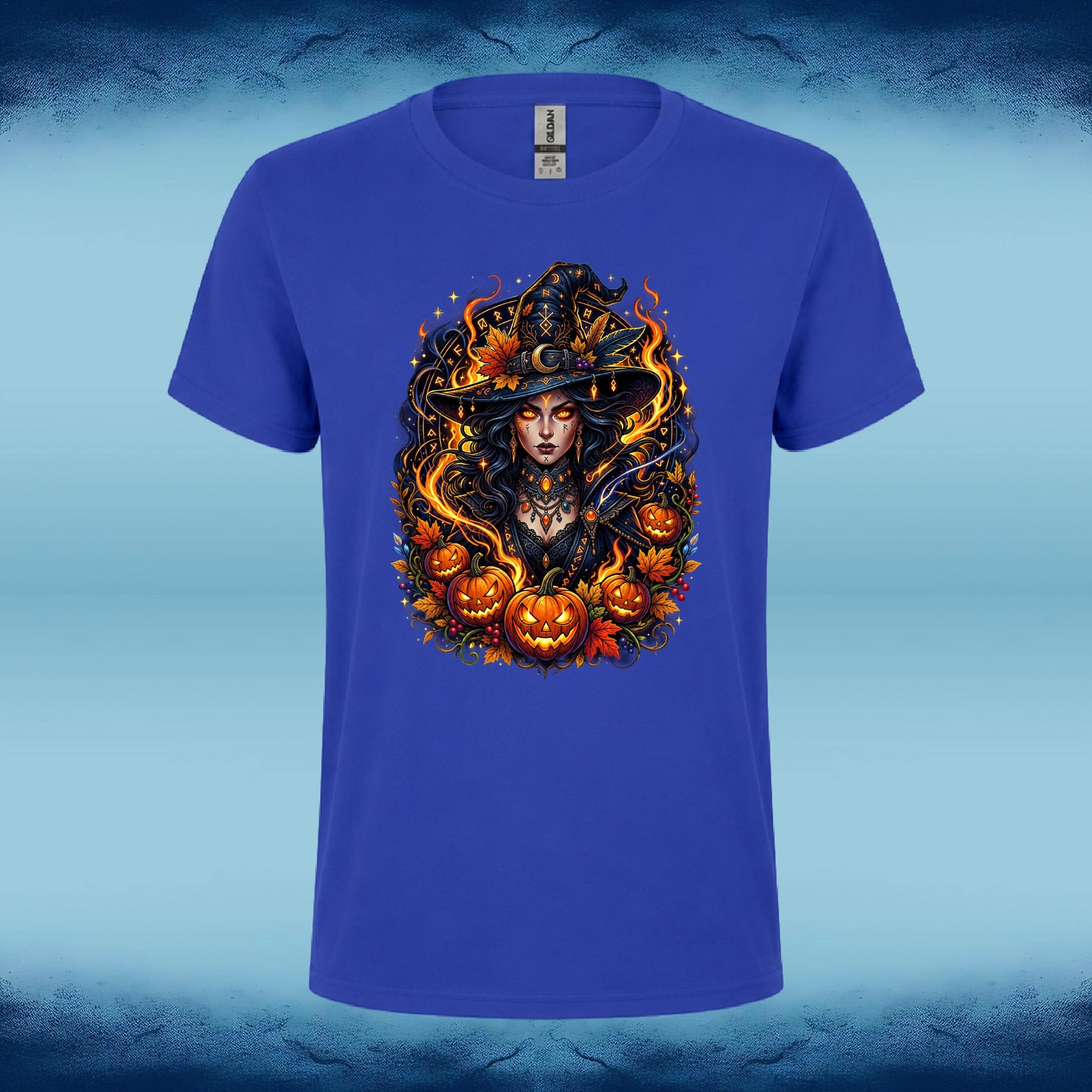 A royal blue short-sleeve t-shirt with a detailed Halloween graphic of a witch surrounded by pumpkins and flames, displayed against a light blue textured background.