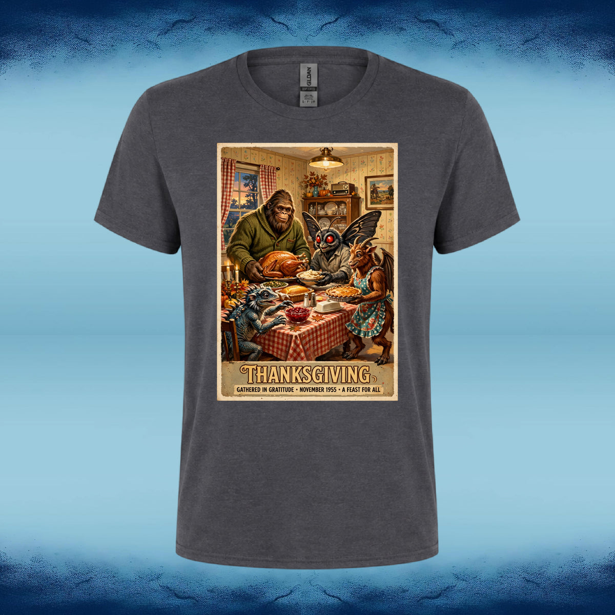 Dark grey crewneck graphic tee featuring Bigfoot, Mothman, and fellow cryptids gathered around a Thanksgiving dinner table.