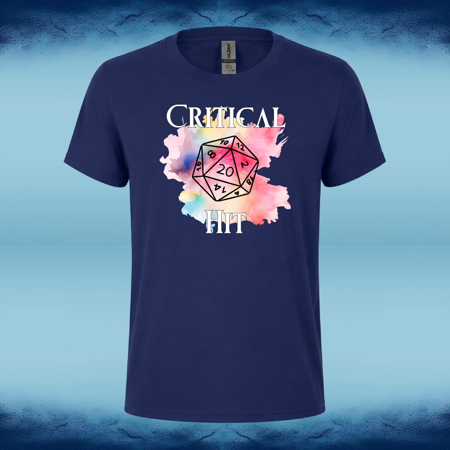 A navy blue short-sleeve t-shirt with a graphic print on the front. The graphic features the text 'CRITICAL HIT' in white, surrounding a colorful watercolor splatter in shades of pink, yellow, and blue, with a black outlined twenty-sided die in the center showing a '20'.