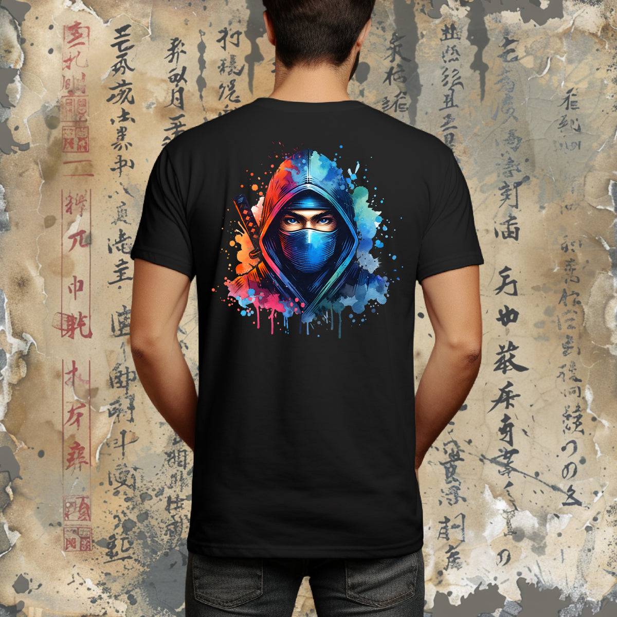 A man wearing a black short-sleeve t-shirt with a colorful graphic of a hooded figure in the center chest, set against a background of aged, textured paper with Japanese calligraphy.