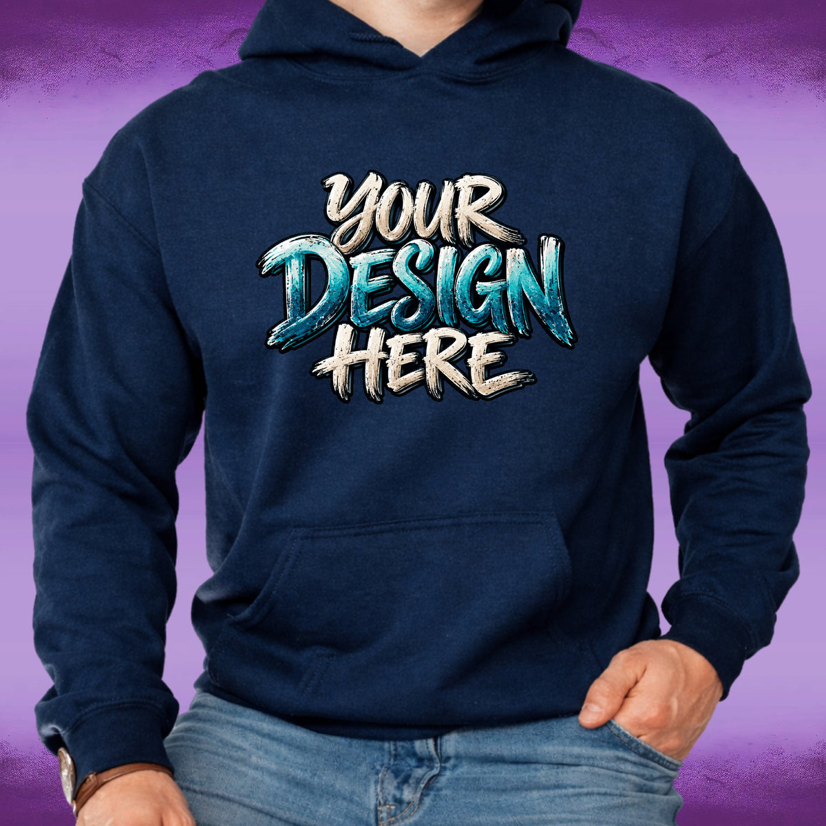 A navy blue hoodie with a customizable graphic print reading 'YOUR DESIGN HERE' in white and teal lettering, worn by a model with blue jeans against a purple gradient background.