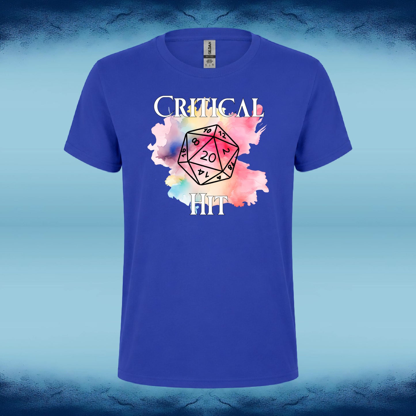 A royal blue short-sleeve t-shirt with a graphic on the front featuring the text 'CRITICAL D20' over a pink, purple, and blue watercolor splash. The shirt is displayed against a blue and light-blue gradient background.
