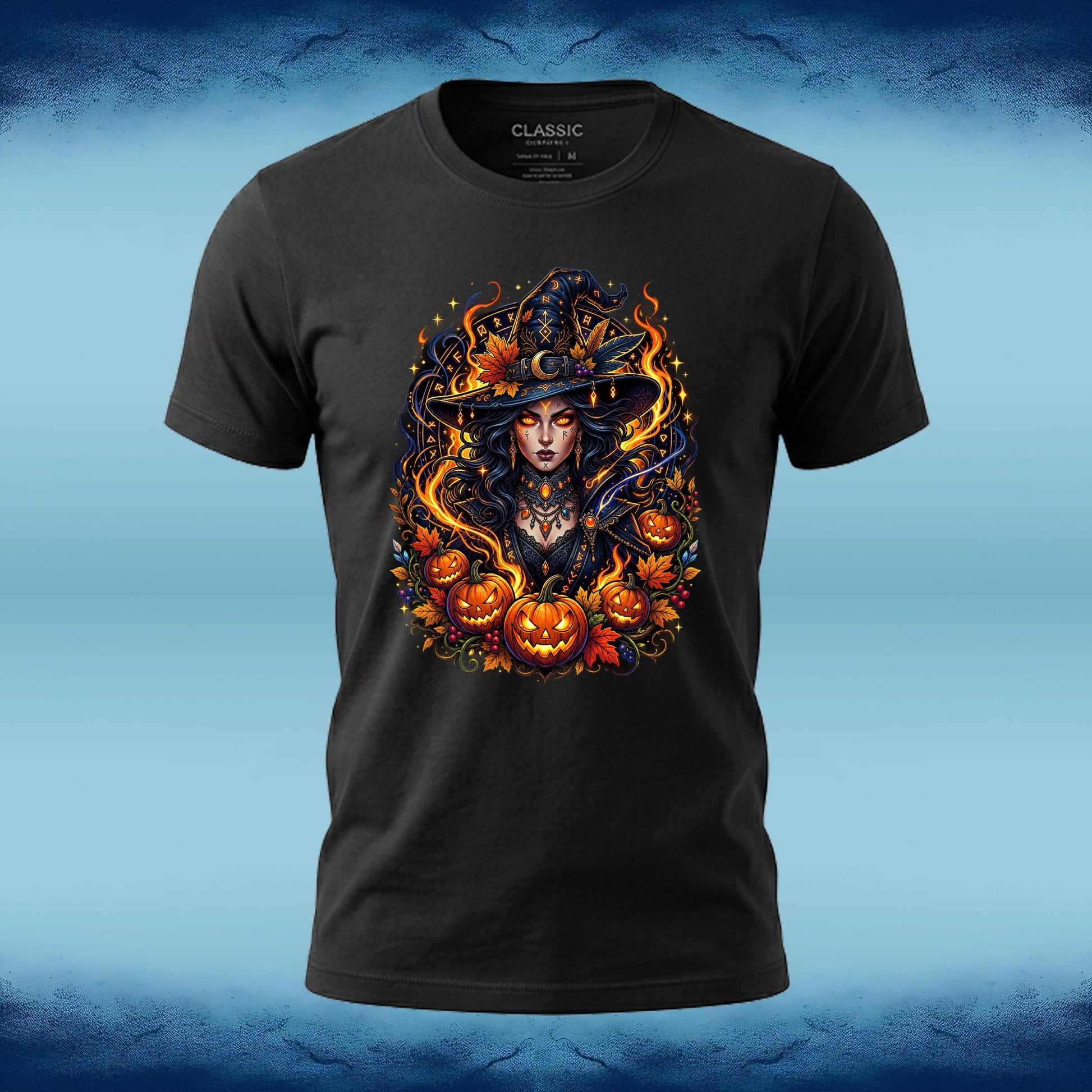 A black short-sleeve t-shirt with a detailed graphic of a witch surrounded by pumpkins and flames, displayed on a blue textured background.