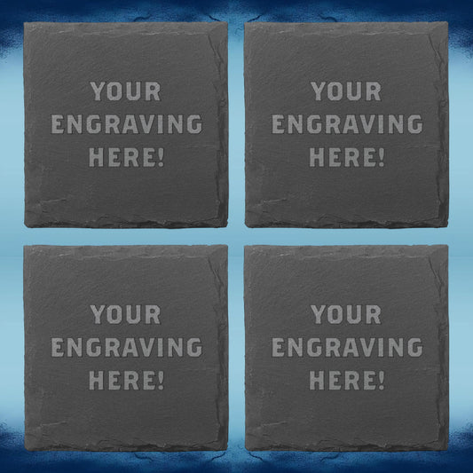 Four square dark gray slate coasters arranged in a 2x2 grid on a blue textured background. Each coaster has light gray placeholder text reading 'YOUR ENGRAVING HERE!'.