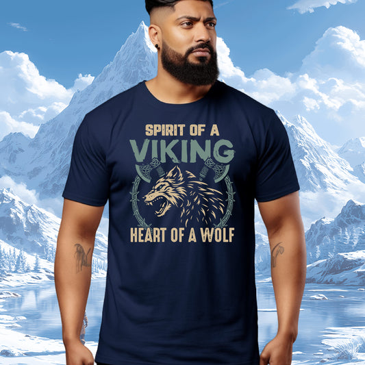 A man wearing a navy blue graphic t-shirt with a Viking wolf design and the text 'SPIRIT OF A VIKING HEART OF A WOLF' against a snowy mountain background.